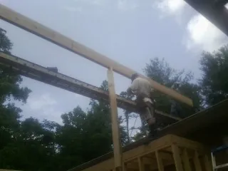 Carpenter setting a ridge beam over a new addition frame — Ice Dam Removal by Roofing Brothers in Browns Summit