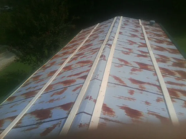 Rusted metal roof panels with new wood purlins before replacement — Storm Damage Roof Repair in Browns Summit by Roofing Brothers