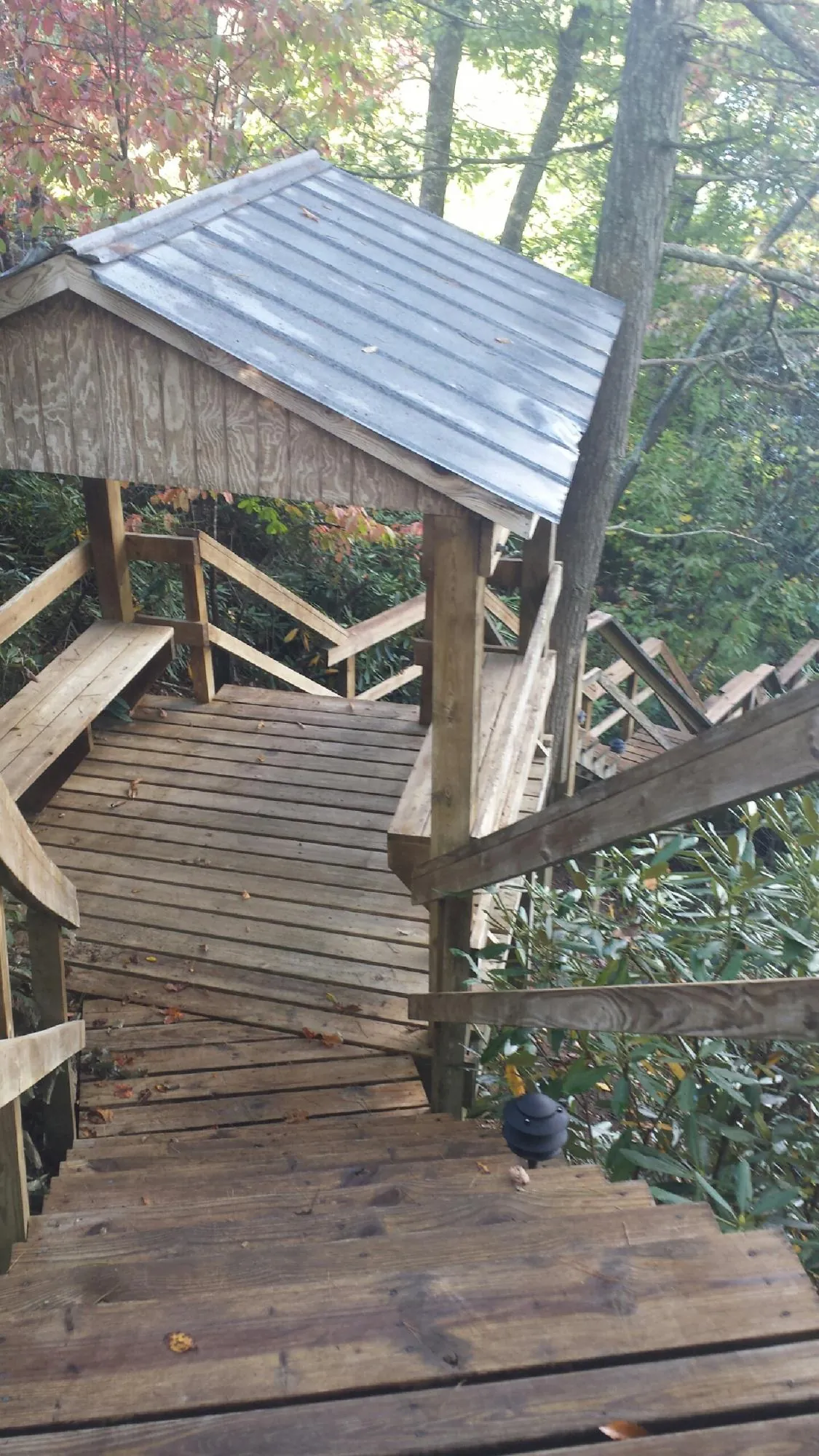 Metal roofed shelter over wooden steps on a wooded walkway — Skylight Repair & Installation work by our crew in Browns Summit