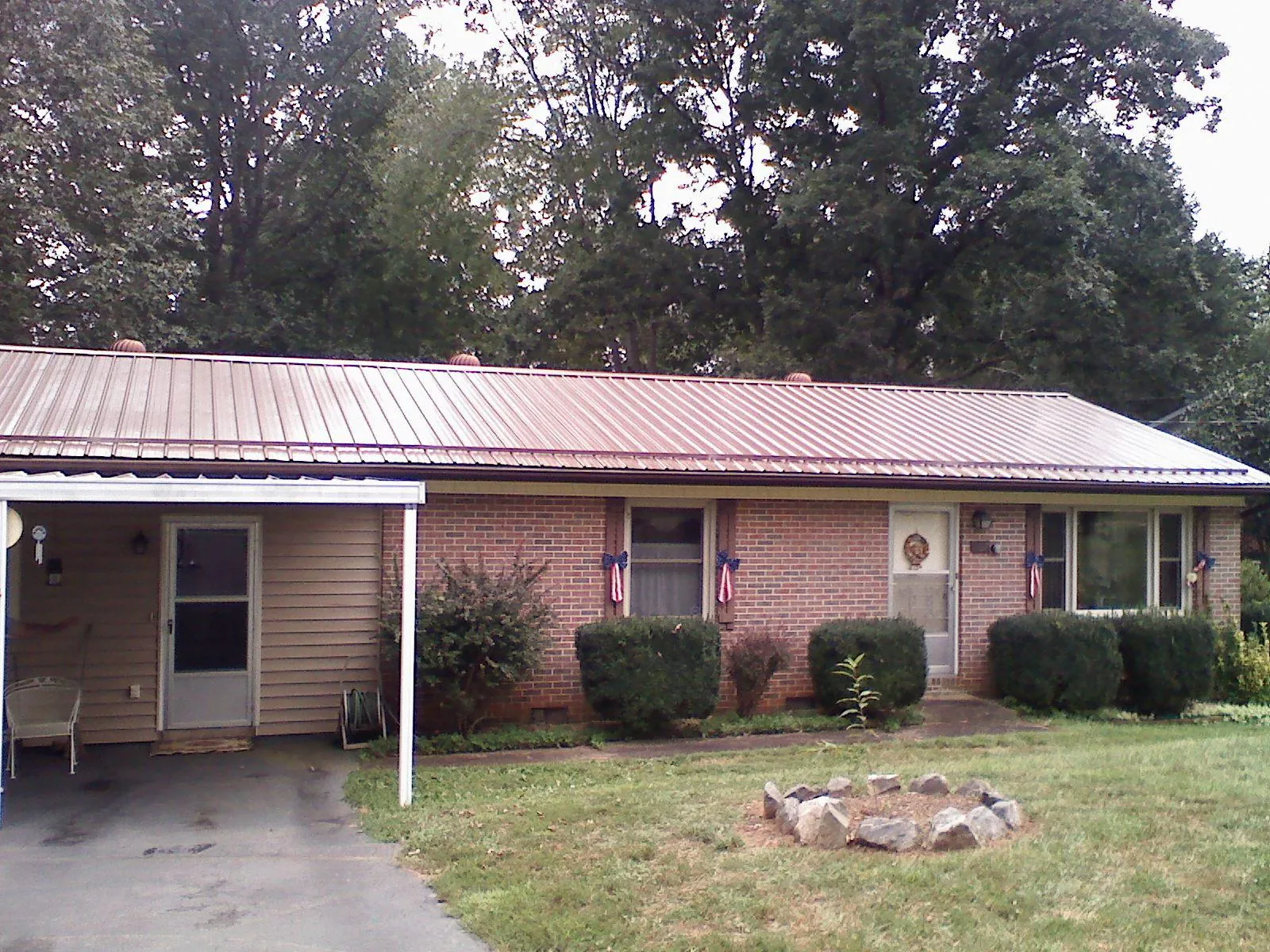 Bronze metal roof and carport on a brick ranch home — Roof Repair work by our crew in Browns Summit